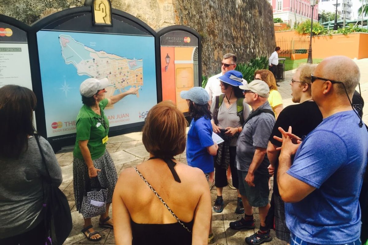Grupo turístico admirando un cartel informativo.