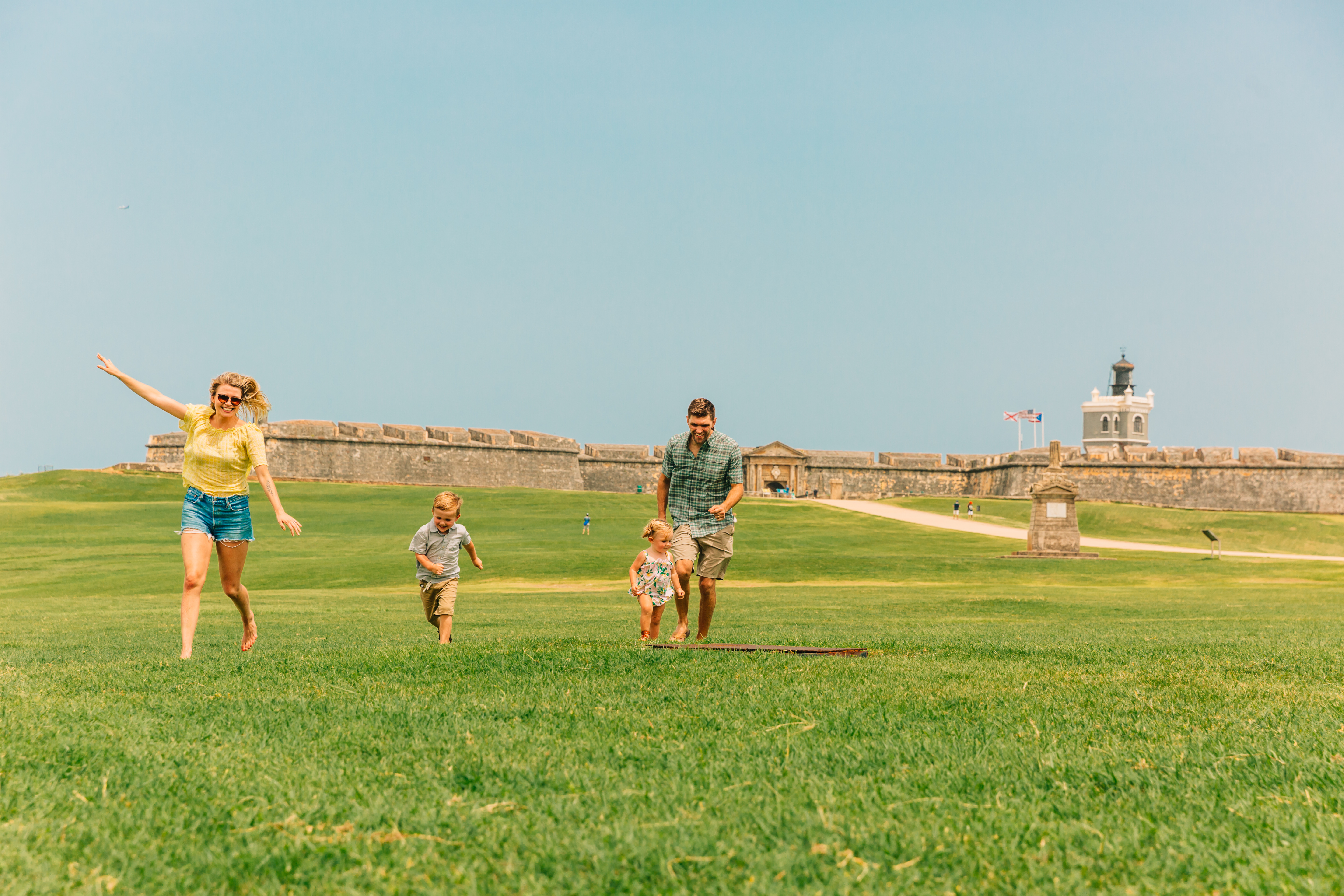 Kids run around the lawn at El Morro