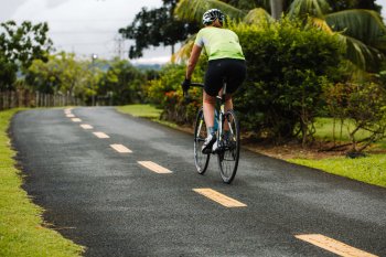 Biker andando en bicicleta a lo largo de un sendero panorámico en el Paseo Lineal, el Parque Central de Bayamón.