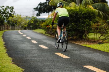 Biker biking along a scenic pathway in Paseo Lineal, Bayamón's Central Park. 