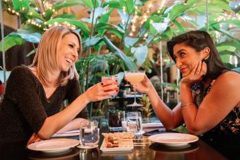 A couple enjoys craft cocktails while dining