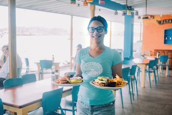 Un mesero sostiene dos platos con deliciosa comida en Culebra.