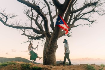 A couple enjoys the outdoors on top of a mountain.