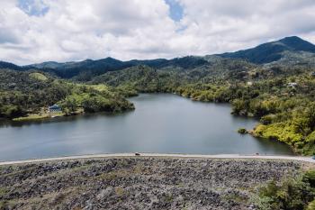 Lago Garzas en Adjuntas con montañas al fondo.