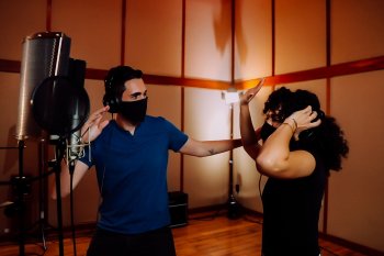 A couple enjoying reggaeton music in a studio.