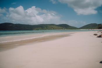 Flamenco beach in Culebra has soft white sand, crystal clear waters, and a backdrop of mountains.