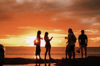 Friends at a beach at sunset.