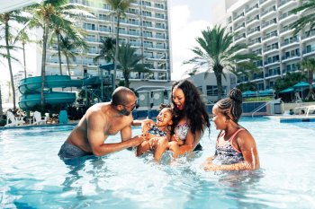 A family plays together in a pool.