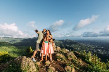 A family poses for a selfie during a hike. 