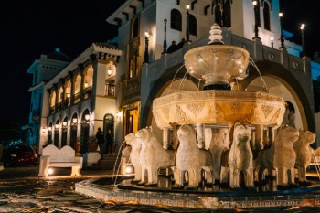 Exterior of the historic Casa de España, featuring an ornate fountain lined with lion sculptures.