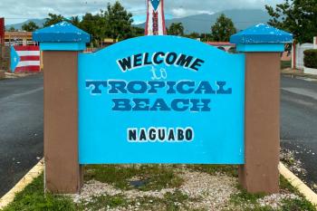 A large entry sign on the road that says "Welcome to Tropical Beach - Naguabo"