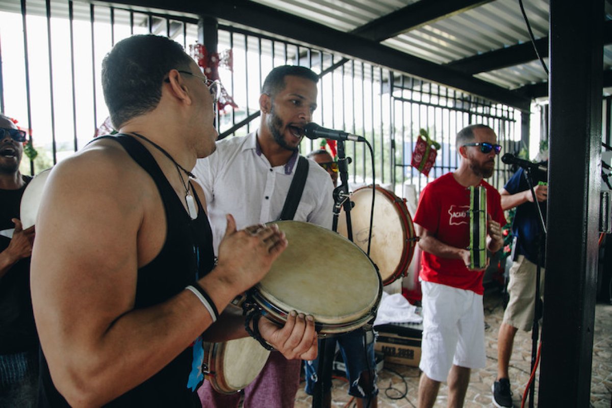 Three men perform at a celebration.