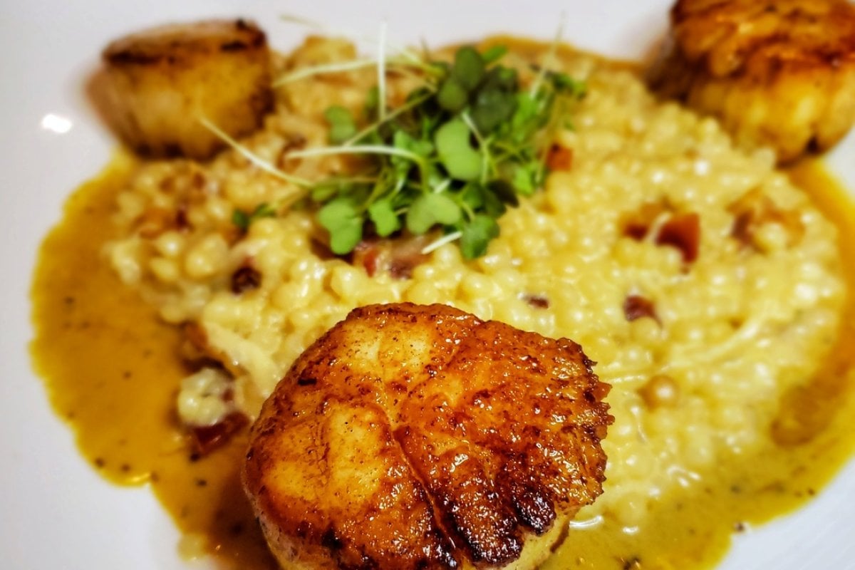 Un hermoso plato con vieiras a la plancha en el restaurante Santaella en San Juan