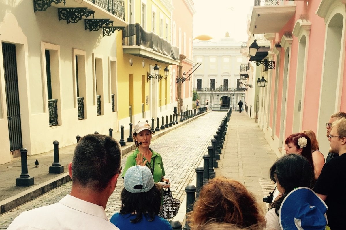 A female tour guide leads a group on a walking tour of Old San Juan.