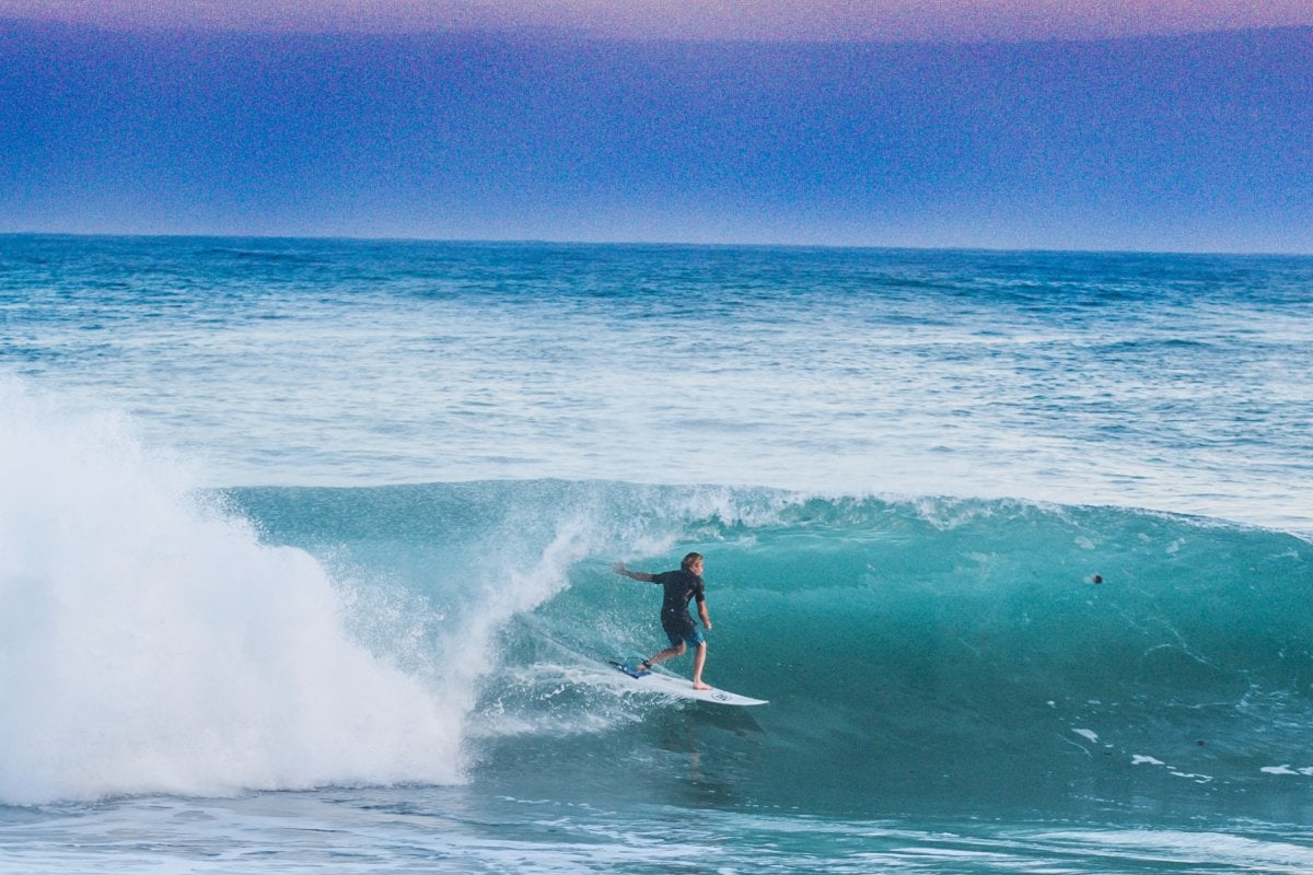 A surfer in Puerto Rico catches a barrel wave at sunset