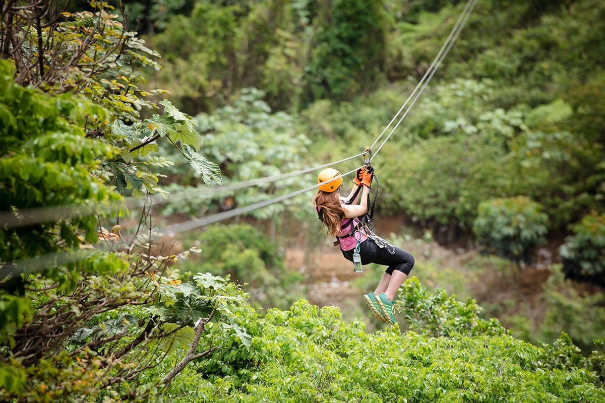 Woman ziplines down a rail at Toro Verde in Orocovis