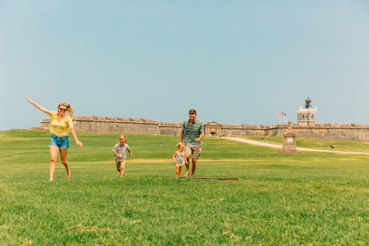 Kids run around the lawn at El Morro