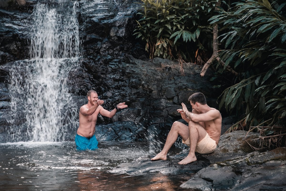 A couple enjoys the day under a waterfall