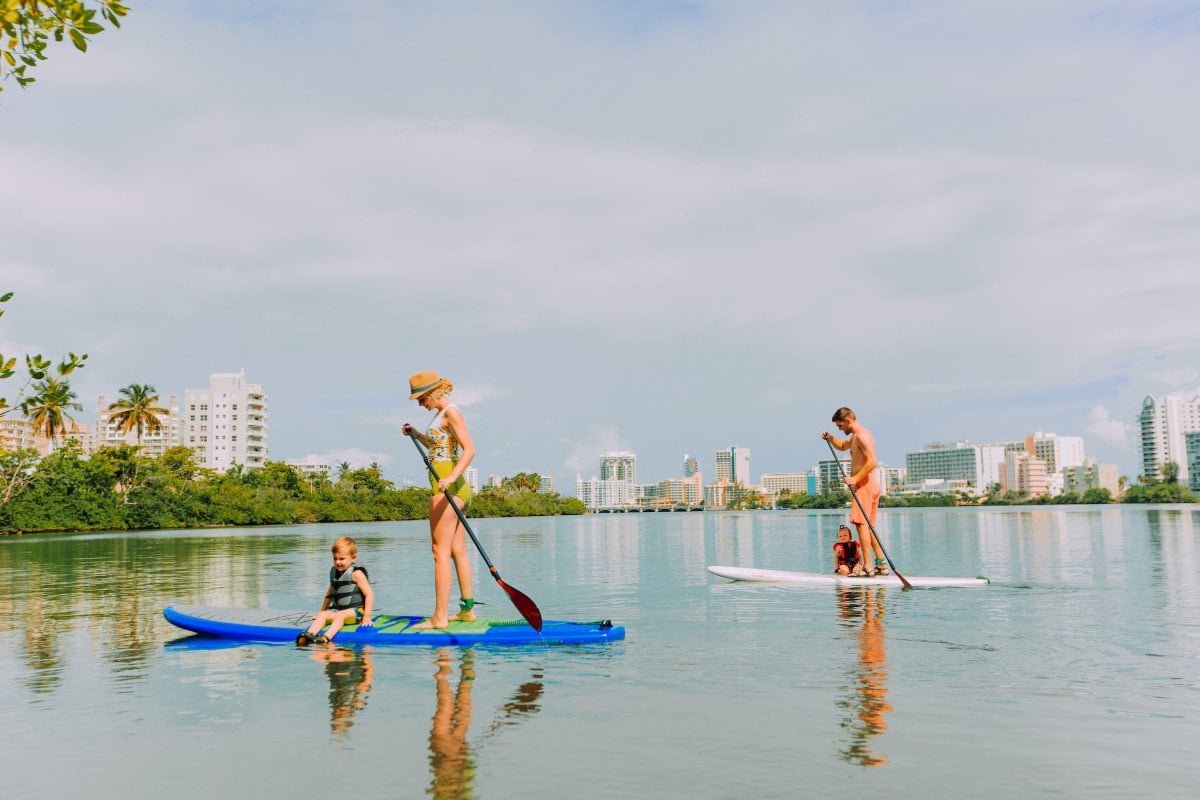 A family paddle boards at the Condado lagoon.