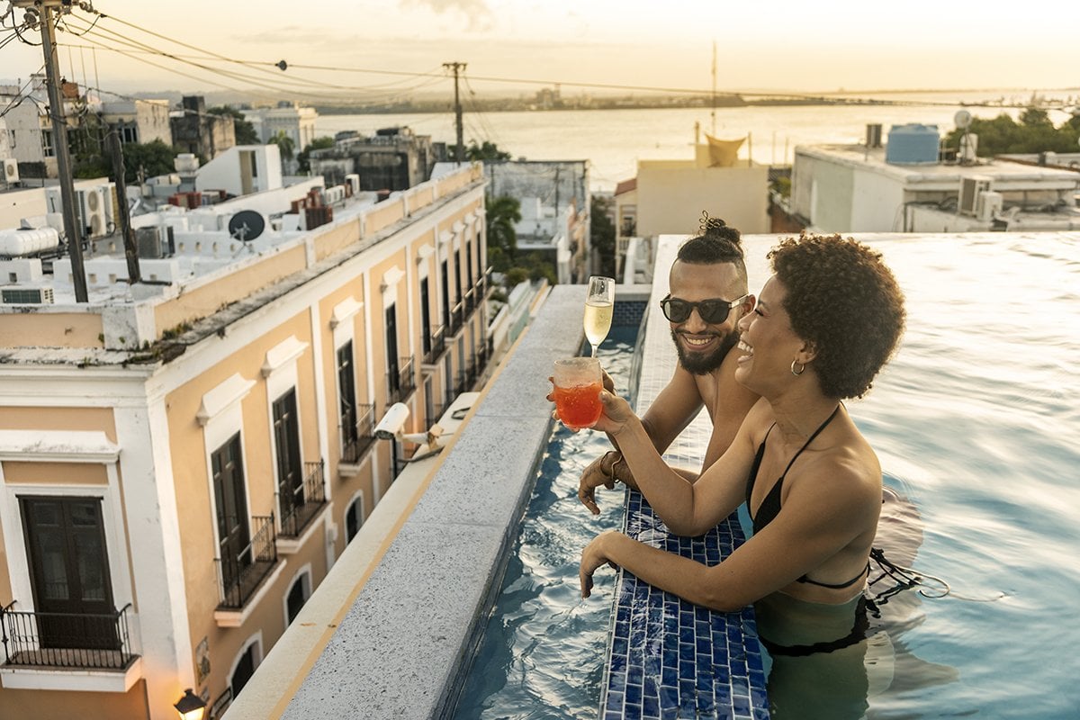 Una pareja disfruta de cócteles en una piscina en la azotea en el Viejo San Juan