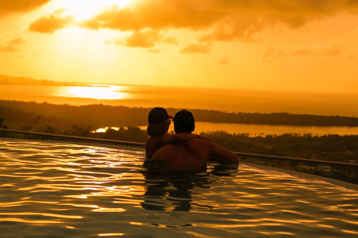 A couple views a sunset from an infinity pool in Puerto Rico.