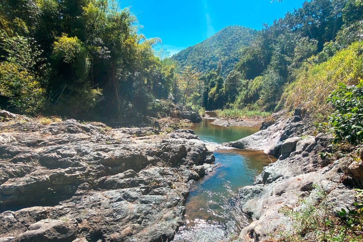 A beautiful natural pool with mountains in the distance along the Río Hondo in Comerío, Puerto Rico.