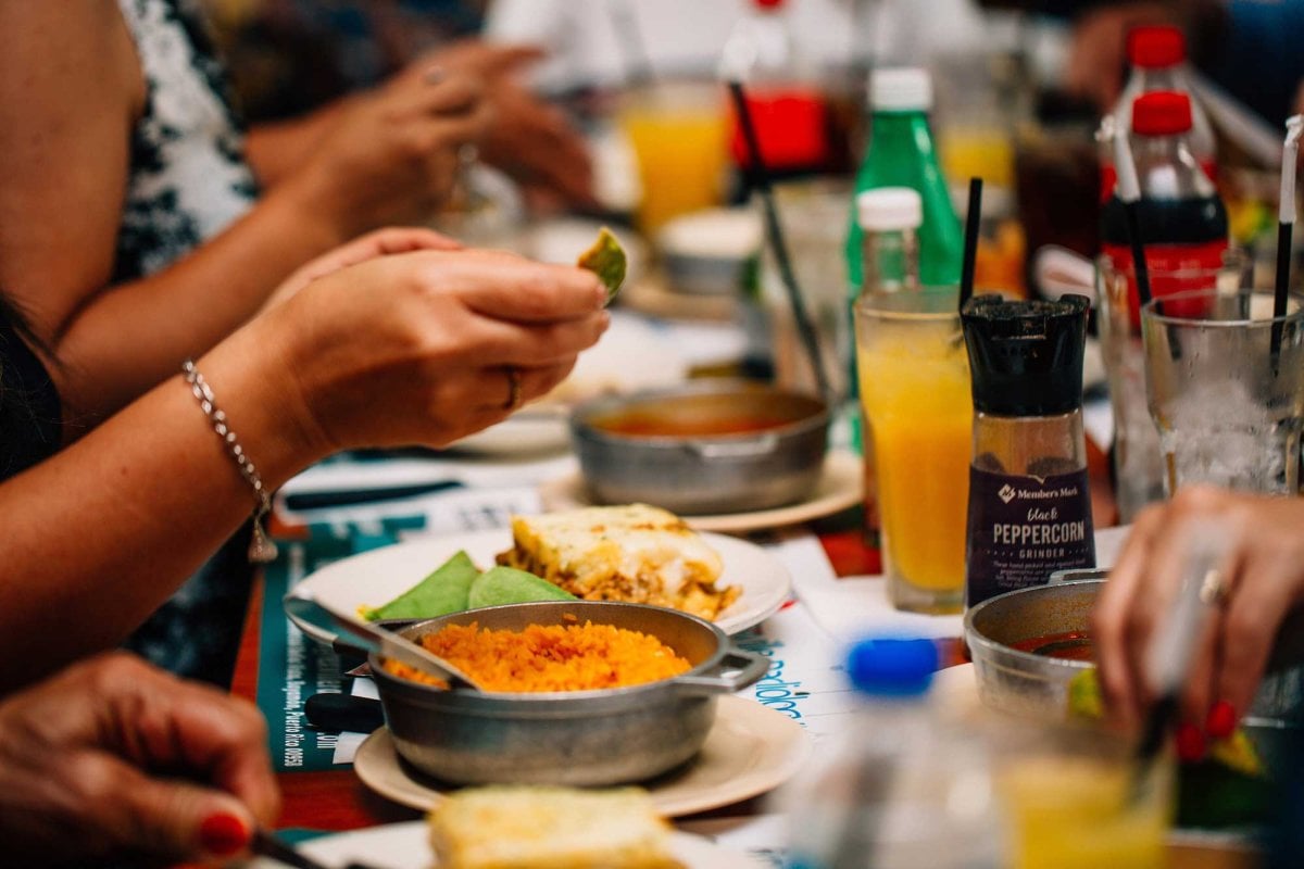 People sit at a long table covered in plates of food at Restaurante Doña Ana in Bayamón, Puerto Rico.