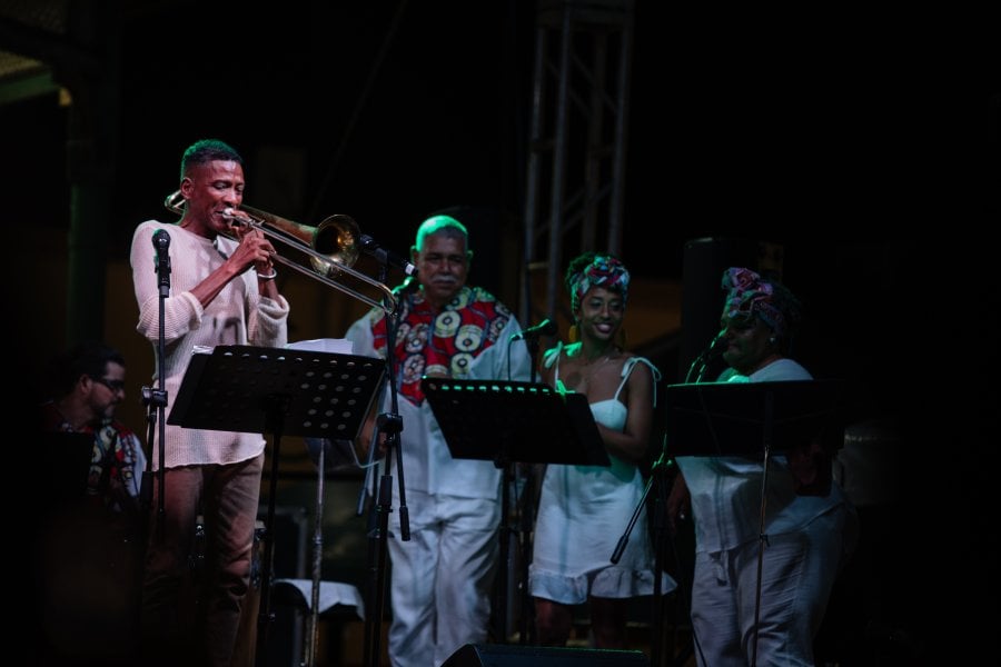 A group of people performing in stage with pleneros and trumpets