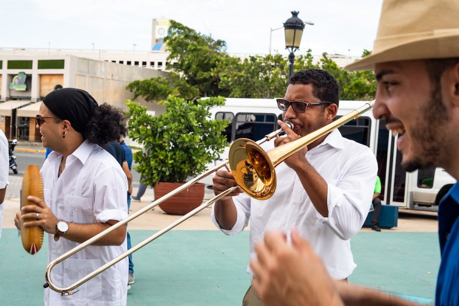 Two people playing the trumpet and a güiro at a plaza in Puerto Rico.