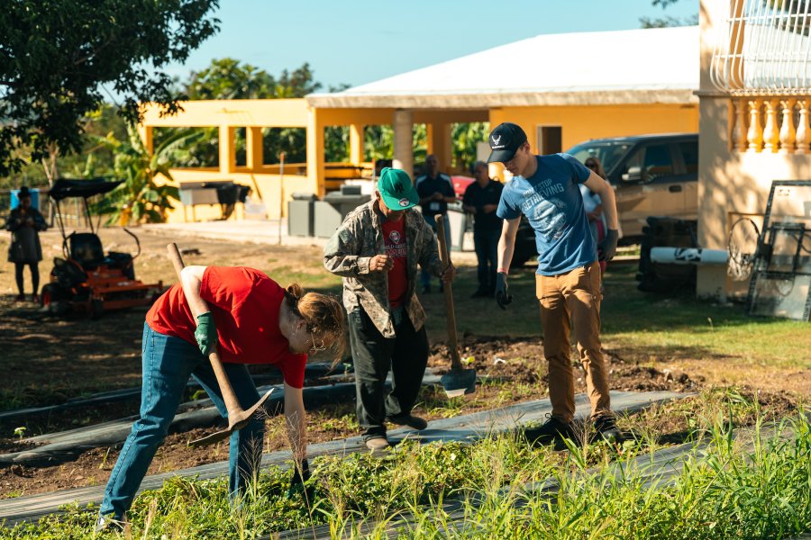 Group of people shoveling and working on a field