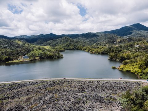 Lago Garzas en Adjuntas con montañas al fondo.