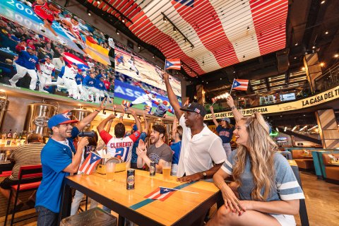 A group celebrates Puerto Rico's baseball team at the Arena Medalla lounge in Distrito T-Mobile