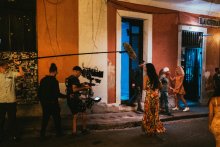 A film crew recording a dancer in Old San Juan, Puerto Rico, a scenic location.