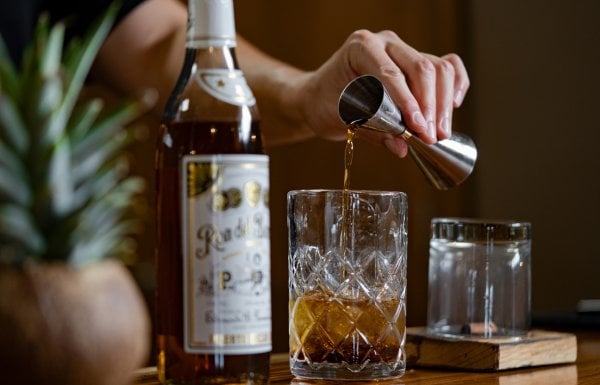 A measured pour of dark rum from Ron del Barrilito