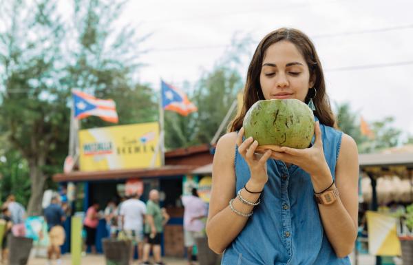 Joven bebe agua de coco en Piñones.