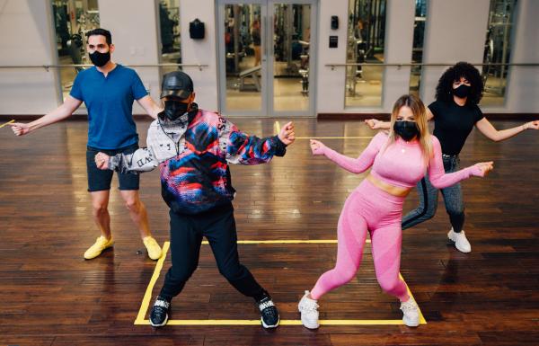 A group of young people learning to dance reggaeton.