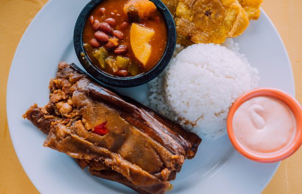 A seeping plate of traditional rice and beans with pasteles and tostones. 