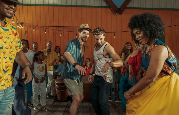 Two men dance with local dancers in Pinones, Puerto Rico