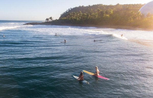 Surfers paddle out to catch a wave at Domes Beach in Rincon, Puerto Rico.