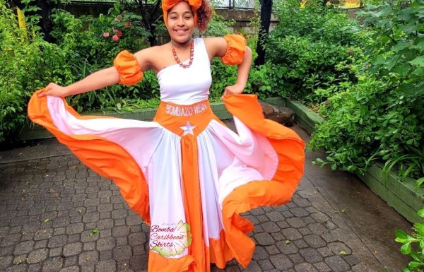 A woman in traditional bomba garb displays her skirt in shades of Puerto Rico Sunshine.