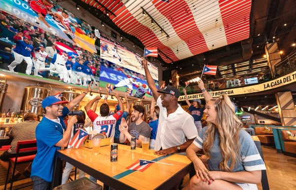 A group celebrates Puerto Rico's baseball team at the Arena Medalla lounge in Distrito T-Mobile