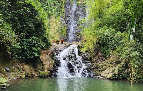 People stand above Chaco Prieto waterfall on a tour by Castillo Tours, Puerto Rico.