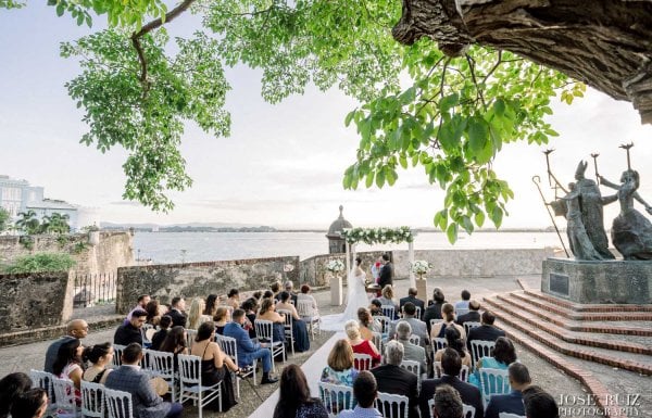 Guests seated for a wedding in front of the iconic La Rogativa statue in Old San Juan.