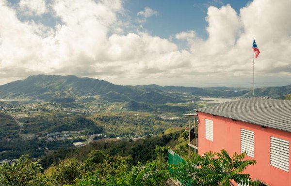 Aerial shot of a house perched over mountains.