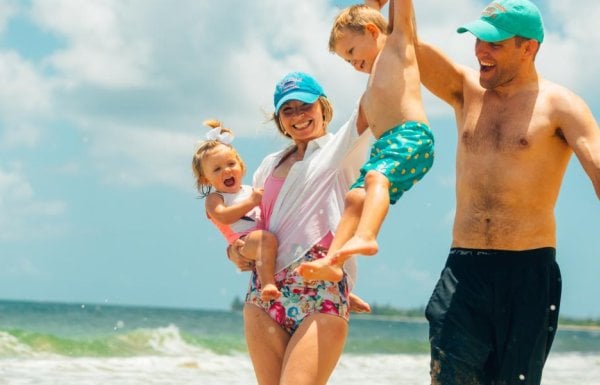 Family of four playing on a beach.