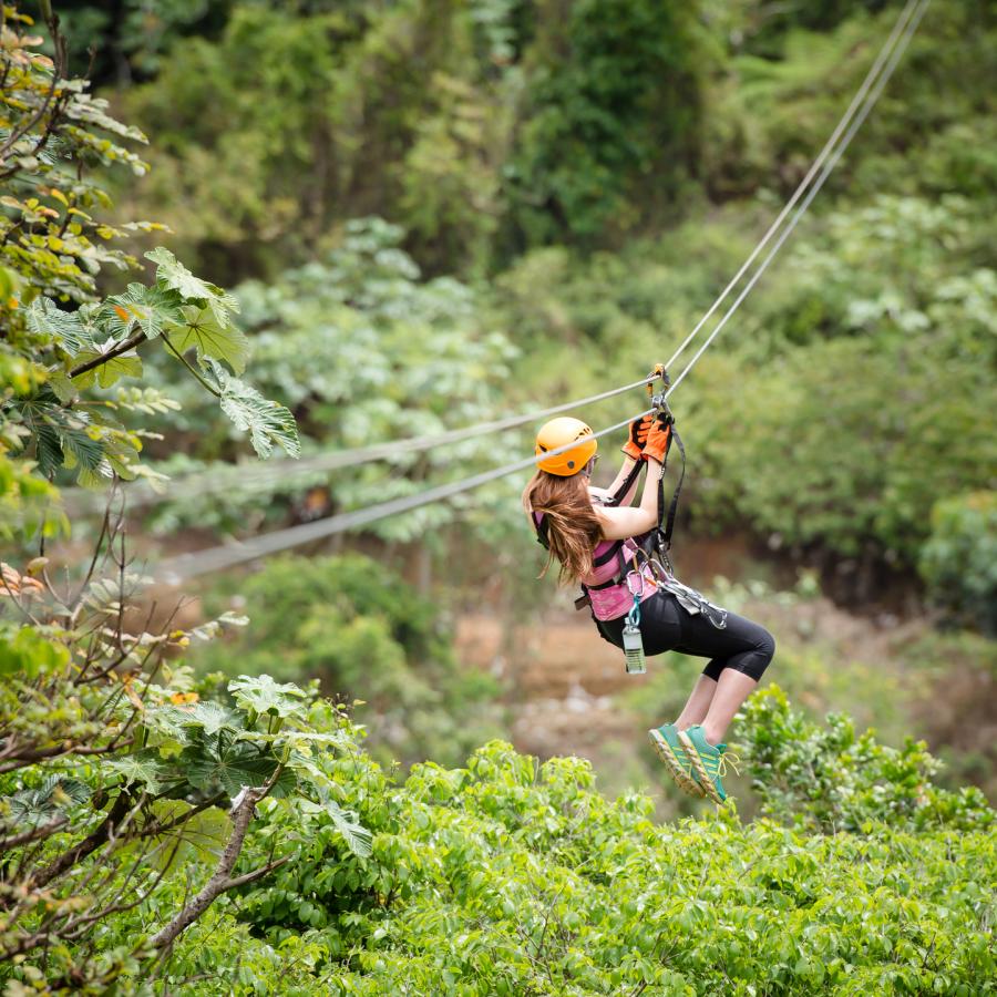 Una mujer vuela por una tirolesa en Toro Verde Adventure Park.