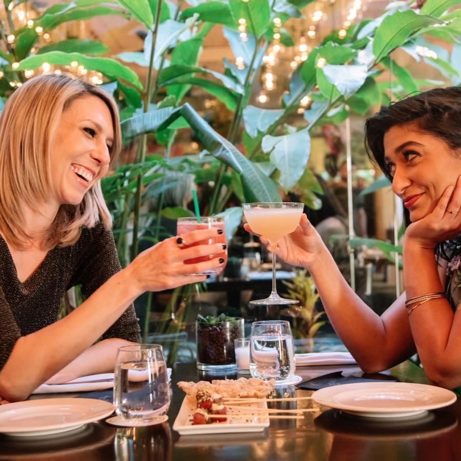 A couple enjoys craft cocktails while dining