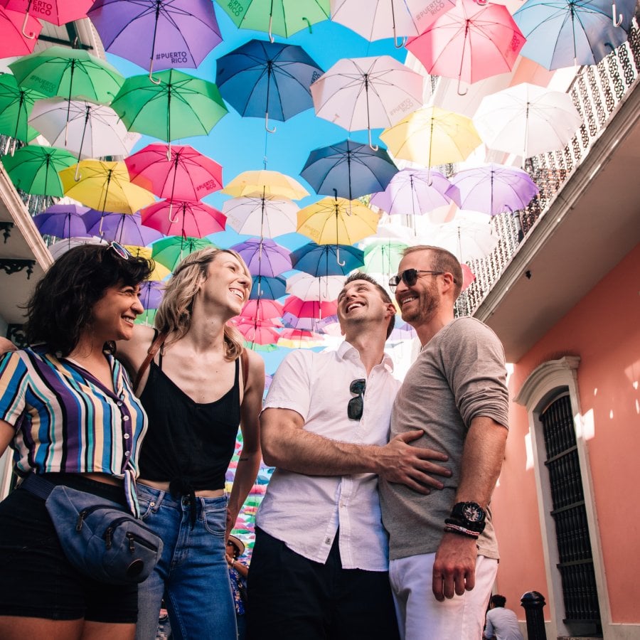 Two couples laugh on the street in old san juan.