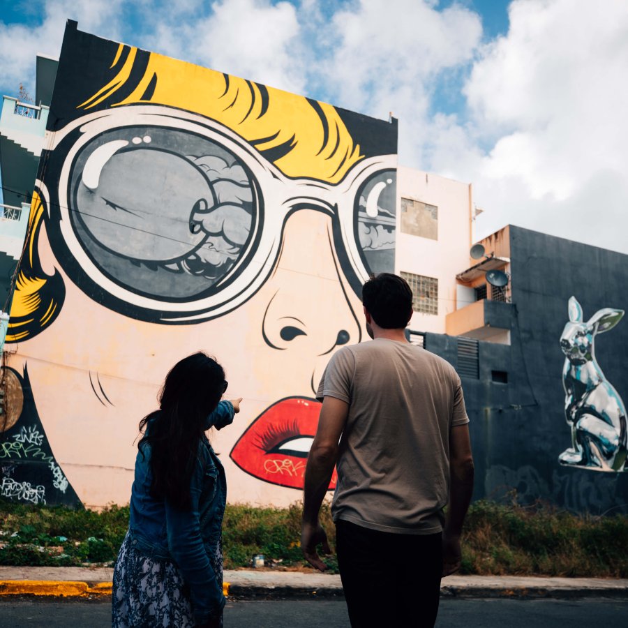 Dos personas admiran los murales en Santurce.