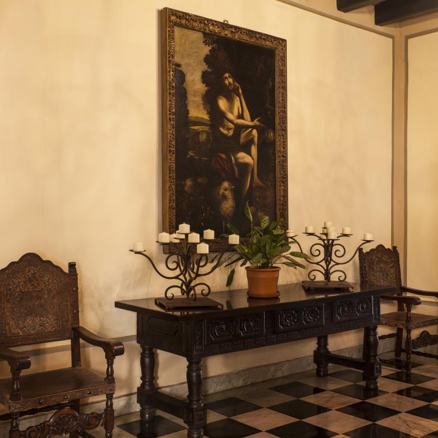 A historic painting hangs on a wall inside el convento hotel